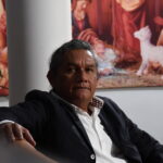 Persona sentada en actitud reflexiva en un entorno tranquilo, invitando a la introspección y al pensamiento consciente.